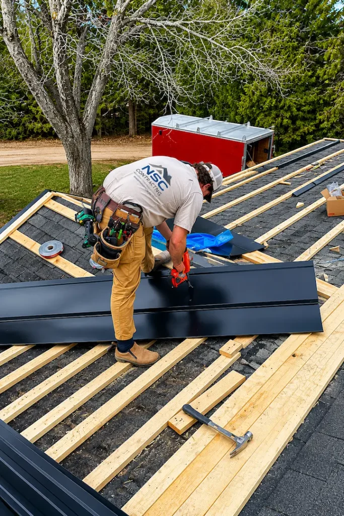 Black ribbed steel roofing panels being installed over strapping on Pontypool home