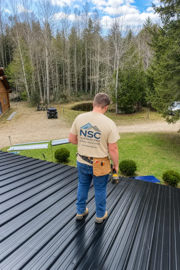 N.S. Custom Contracting roofer installing spruce strapping on Pontypool roof with property and pond in background